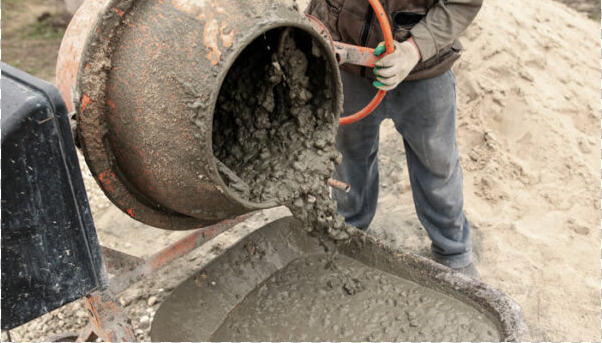 Man pouring wet material from ready mix concrete mixer into wheelbarrow